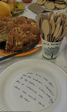 A plate with writing on it, spoons and a cake.